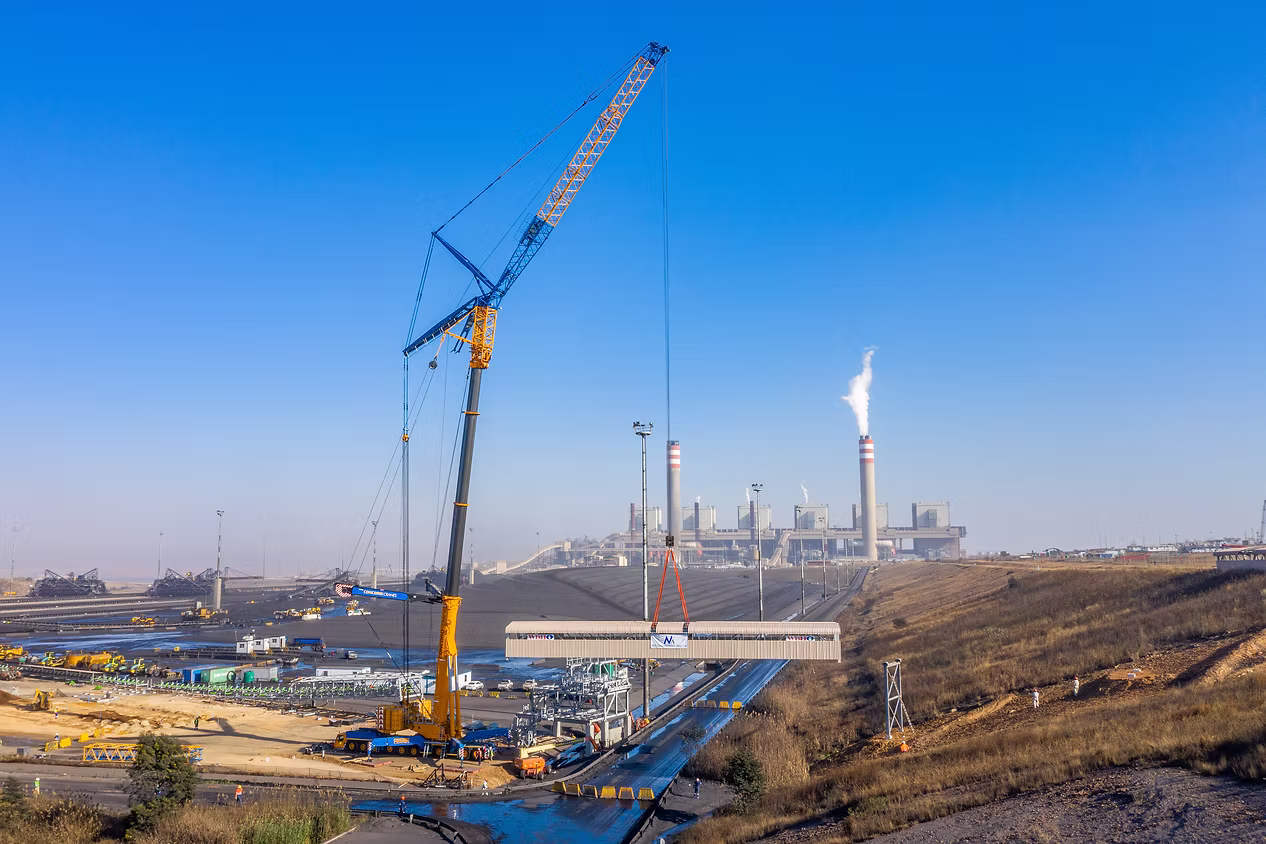 Crawler crane lifting a steel girder at the New Largo facility